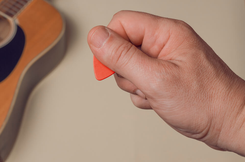 how to hold guitar pick